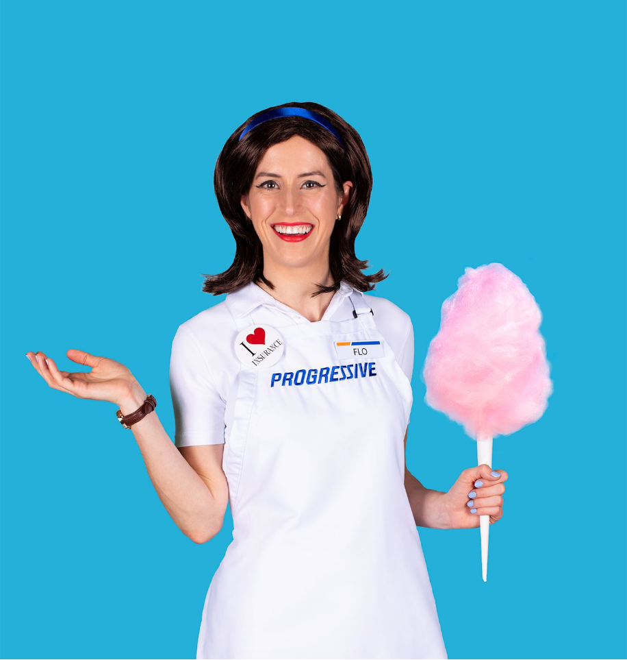 Woman modeling a Halloween costume resembling Flo, the Progressive Insurance spokesperson, against a blue background.