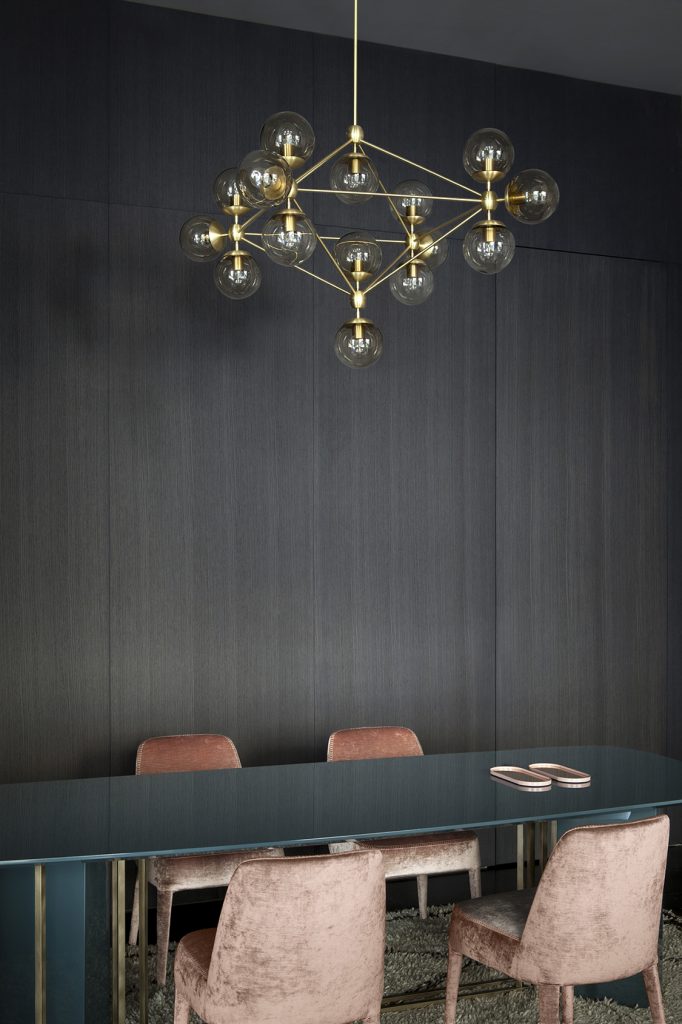 Modern gold light fixture over long dining table